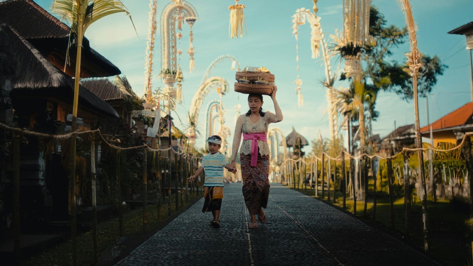 Authentic Bali experiences walking through a Balinese village ceremony with traditional offerings and penjor poles